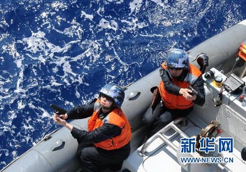 　3月28日，十余名臨檢拿捕隊員乘小艇駛至模擬可疑商船下方水面。