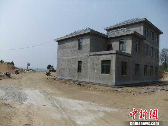 鴨河水庫(kù)庫(kù)區(qū)邊的新建別墅，一面墻上寫著“拆”，另一邊在加緊施工。吳揚(yáng)　攝