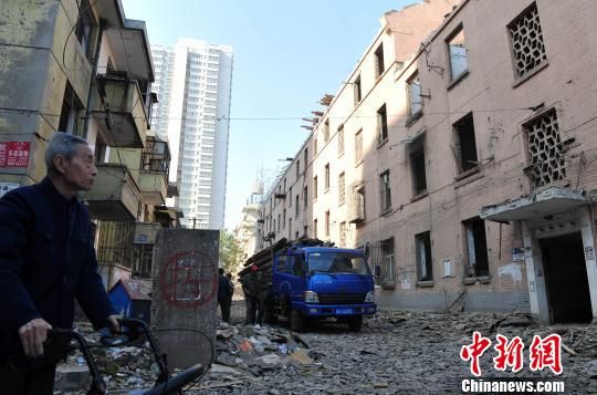 一位花甲老人站在即將拆除的樓房旁，默默地與“蘇聯(lián)樓”告別。　翟羽佳　攝
