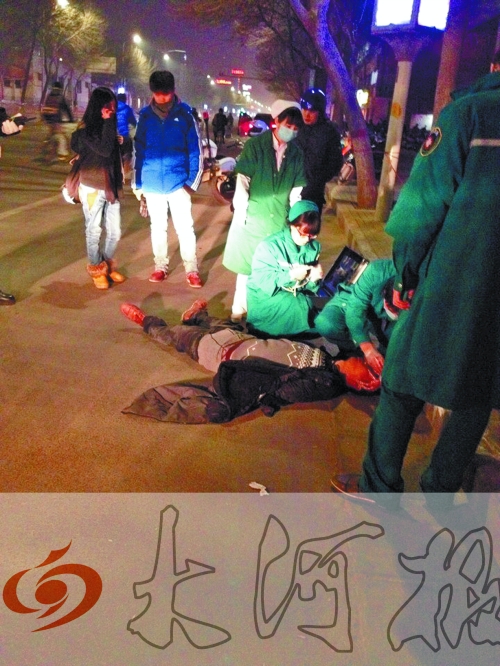 醉漢躺在地上，醫(yī)護(hù)人員對其進(jìn)行檢查。
